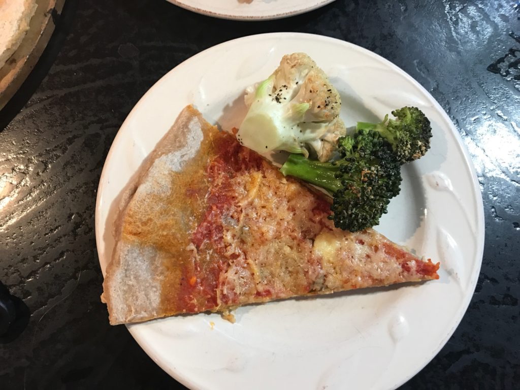 pizza plated with broccoli and cauliflower